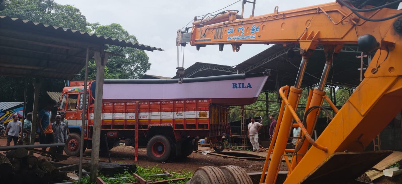 ಲಾರಿಗೆ ದೋಣಿ ಏರಿಸುವಿಕೆ — ACE hydraulic crane lifting a fishing boat onto a lorry in Bhatkal