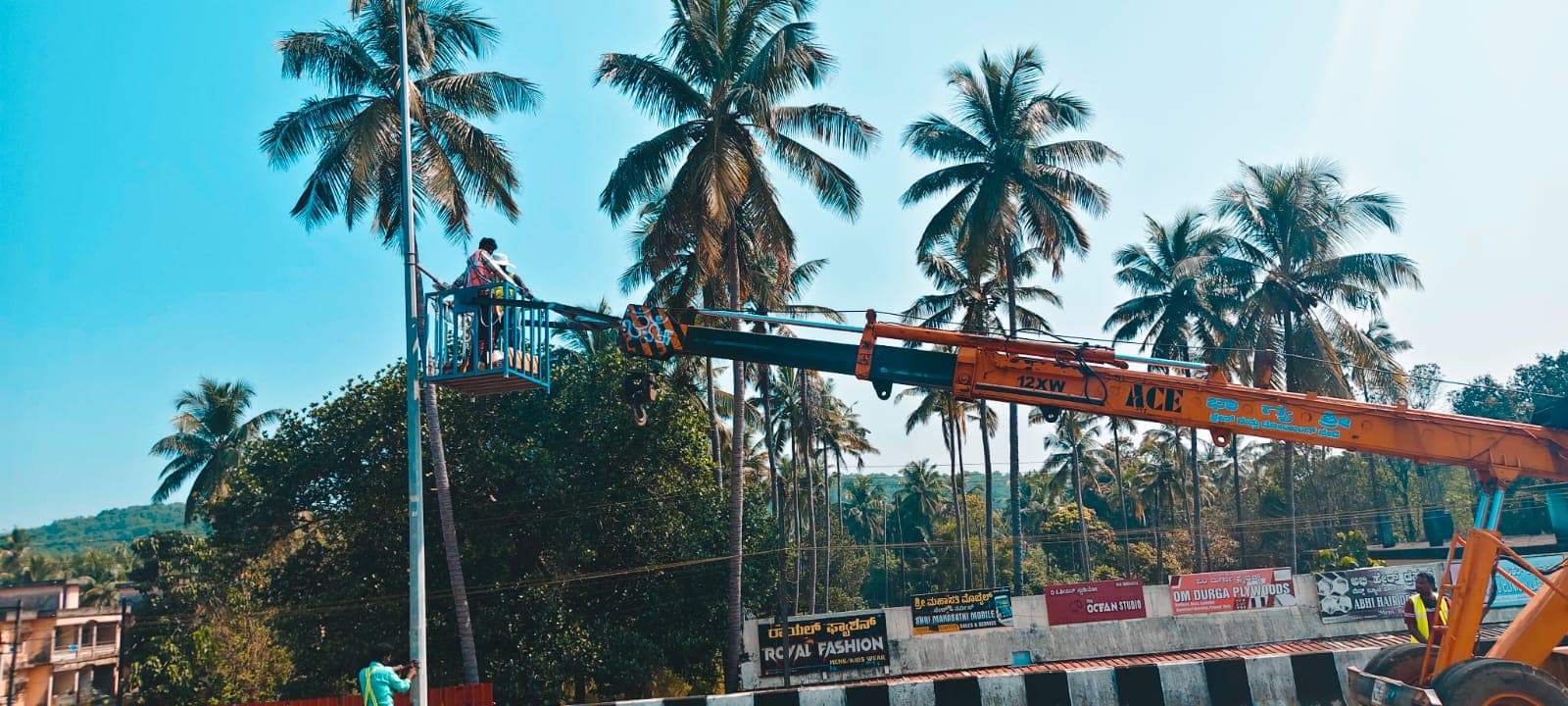 ಮ್ಯಾನ್ ಬಕೆಟ್ — ಎತ್ತರದ ಕೆಲಸದ ವೇದಿಕೆ — Bhagyashri crane man bucket lifting workers to a streetlight pole in Bhatkal